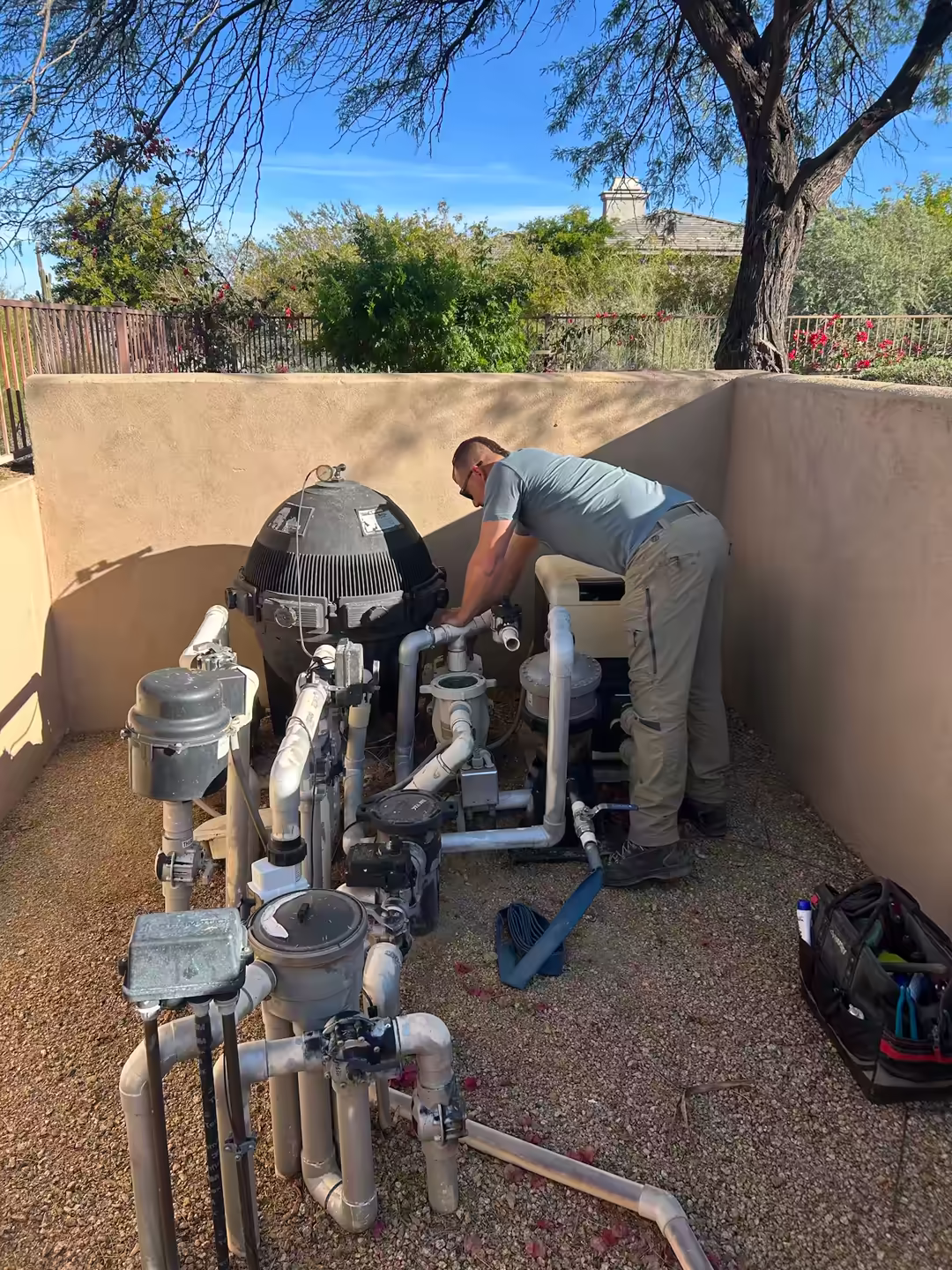 A pool technician treating a green pool in the Arizona desert